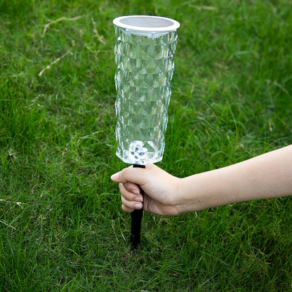 Havenlia solar rose garden stake light glowing in flower bed at dusk