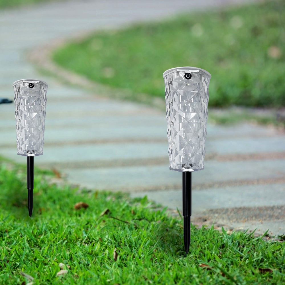 Havenlia solar rose garden stake light glowing in flower bed at dusk